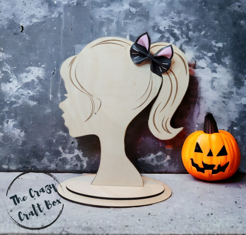 Whiskers n Bows black faux leather cat ear hair bow displayed on a wooden mannequin head next to a small pumpkin