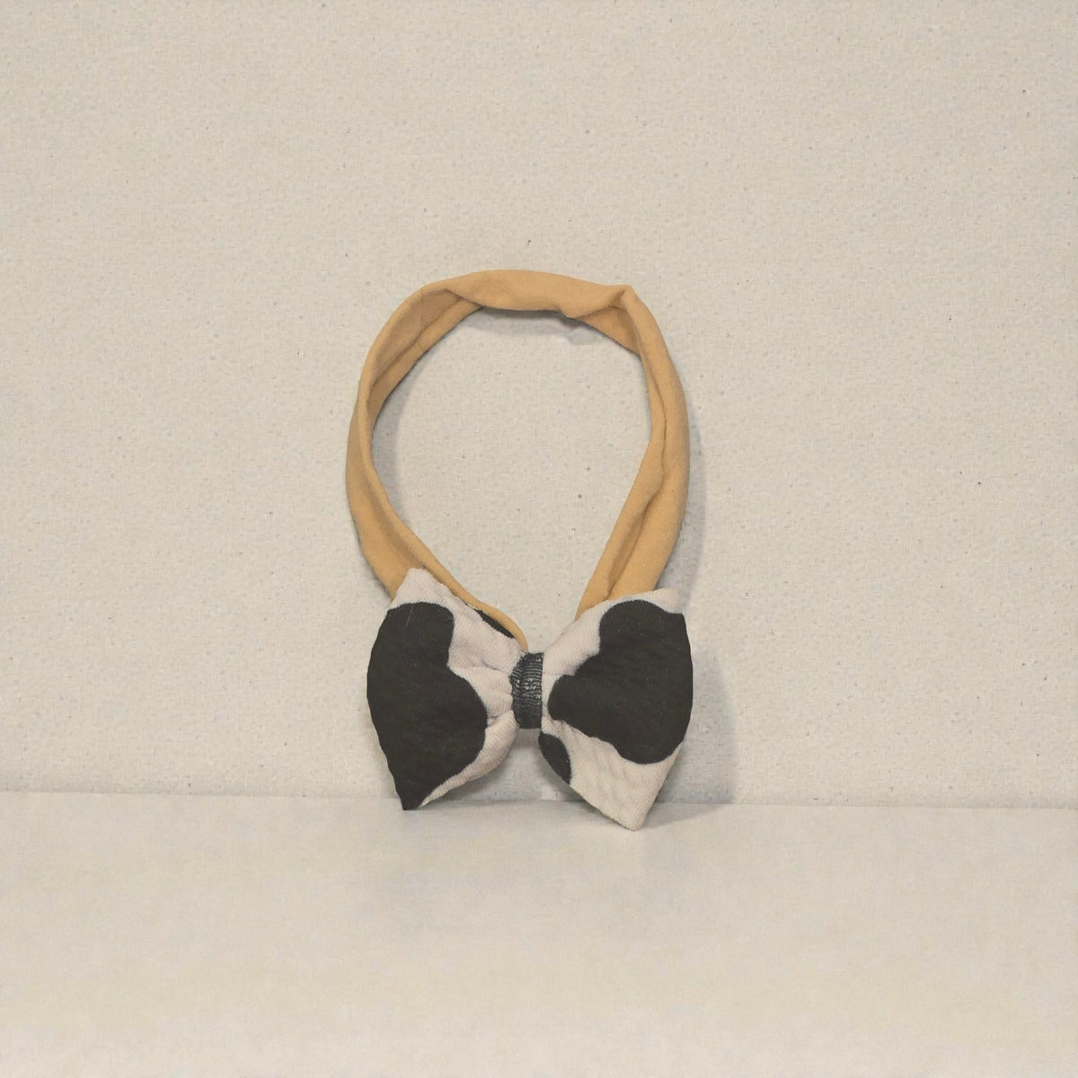 Whiskers n Bows black and white cow print bow headband with a soft tan elastic band for comfortable hair styling