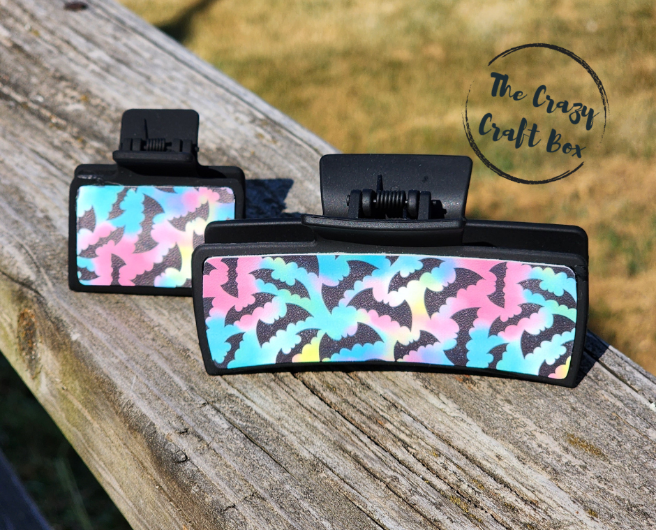Whiskers n Bows Halloween hair claw clips in 4-inch and 2-inch sizes with a black frame and iridescent bat pattern.