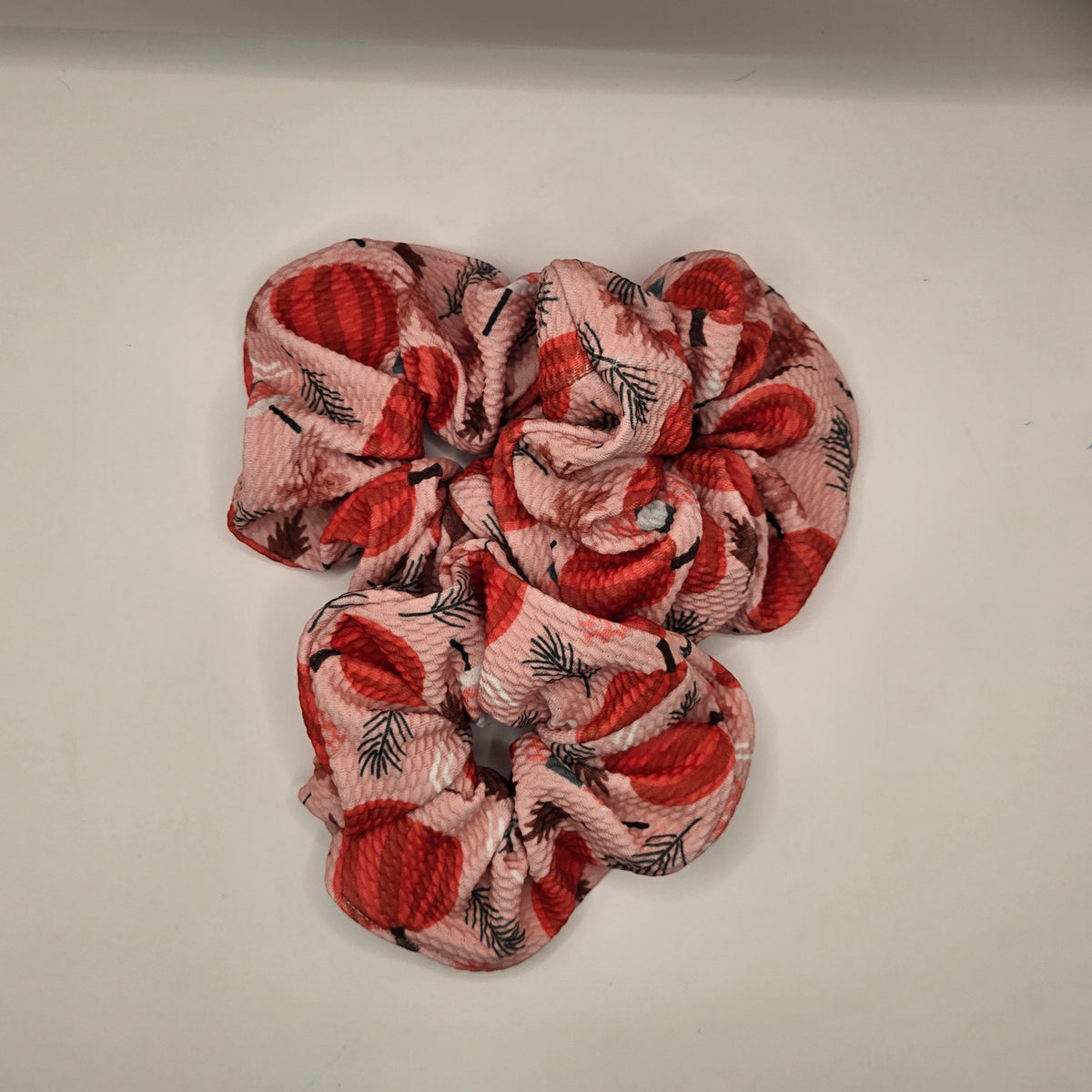 Whiskers n Bows pink fabric scrunchie featuring a festive red pumpkin and pine leaf print for autumn hair styling.