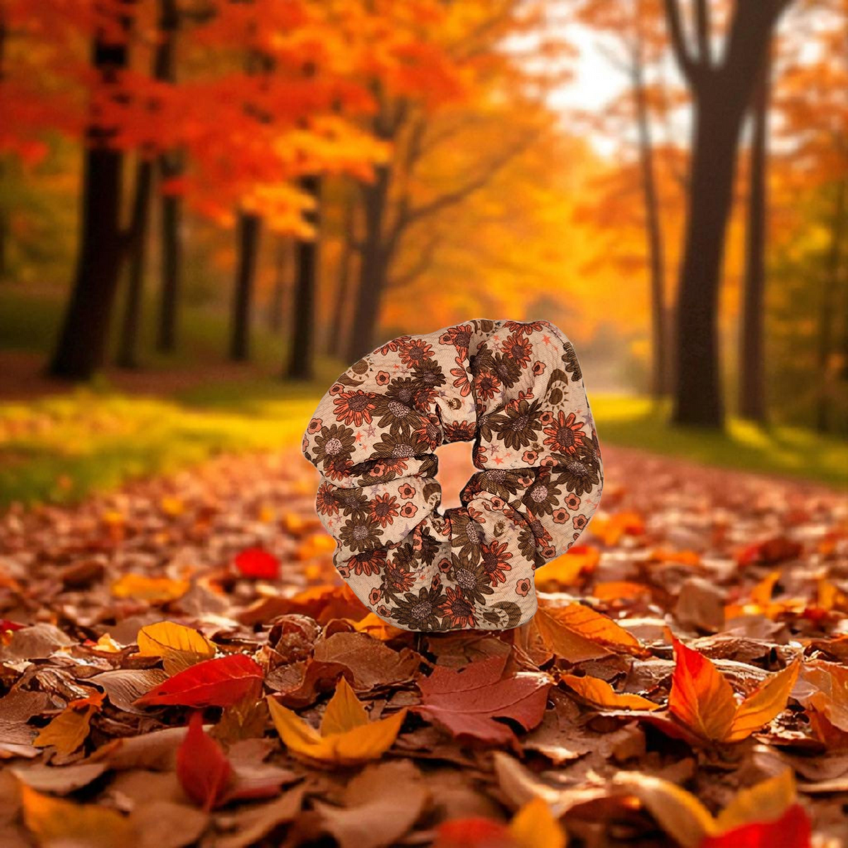 Whiskers n Bows vintage floral scrunchie in rust and cream, displayed on a forest path covered in autumn leaves.